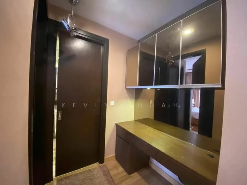 Room features: wooden flooring, brown painted walls, mirror with multiple panels, built-in wooden desk, ceiling light fixture, door with dark wood finish, rug on floor; style: modern.