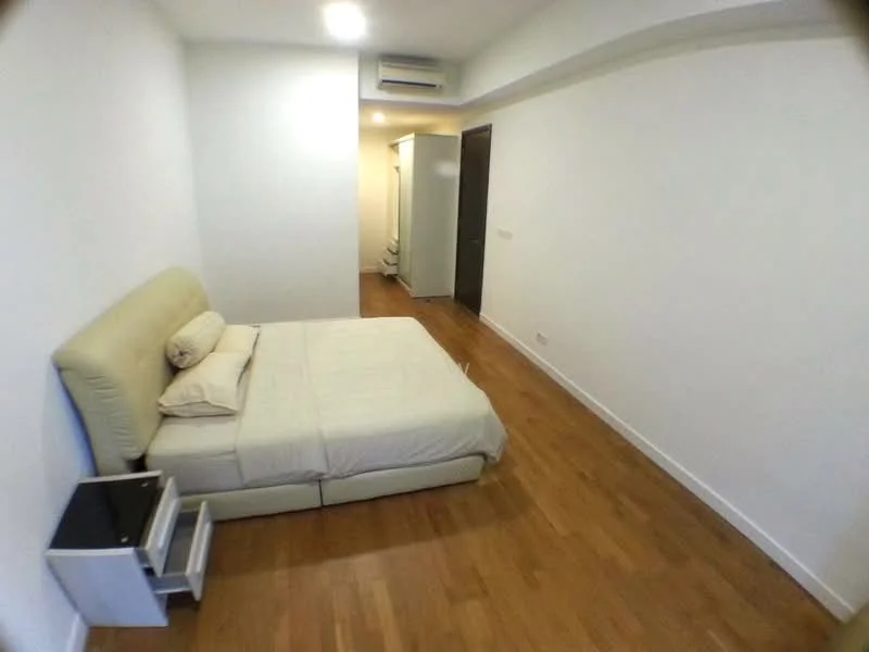 Bedroom features: queen-size bed with beige upholstered headboard, light wood flooring, white painted walls, recessed downlights, 1 wall-mounted split AC, nightstand with drawer, open closet space, door leading to hallway; style: modern.