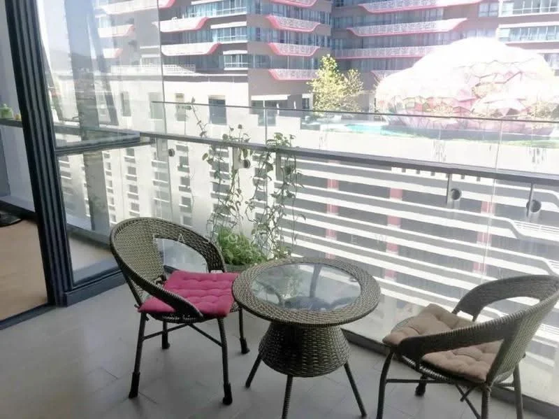 Balcony features: glass railing, two wicker chairs with cushions, round glass-top table, potted plants, floor tiles, view of building facade, view of pool area; style: modern; view: pool.
