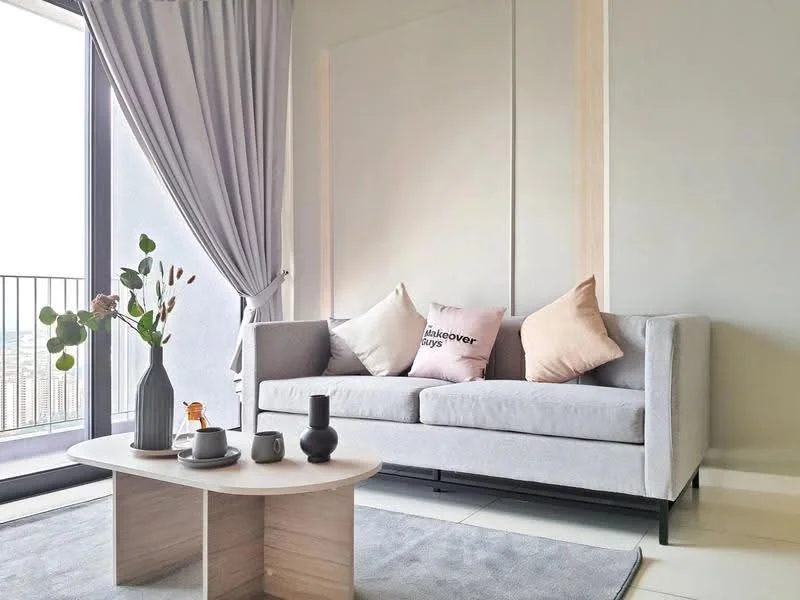 Living features: grey fabric sofa, decorative cushions in pink and beige, light wood coffee table, vase with greenery, black decorative vase, ceramic cup, minimalist decor, floor-to-ceiling windows, curtains in light grey, neutral wall color, area rug in light color; style: modern; view: city.