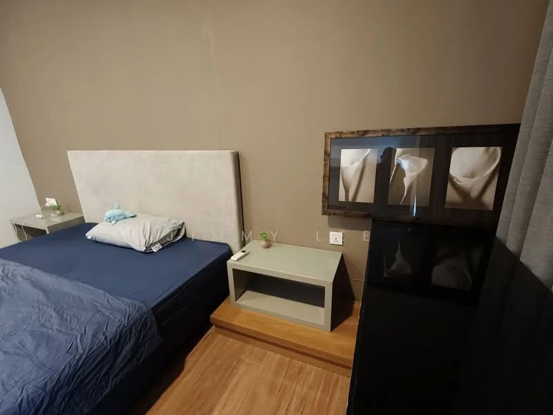Bedroom features: queen-size bed with upholstered headboard, blue bed linens, nightstand with drawer, framed artwork on wall, wooden flooring, grey curtains, table lamp on nightstand, decorative plush toy on bed; style: modern.