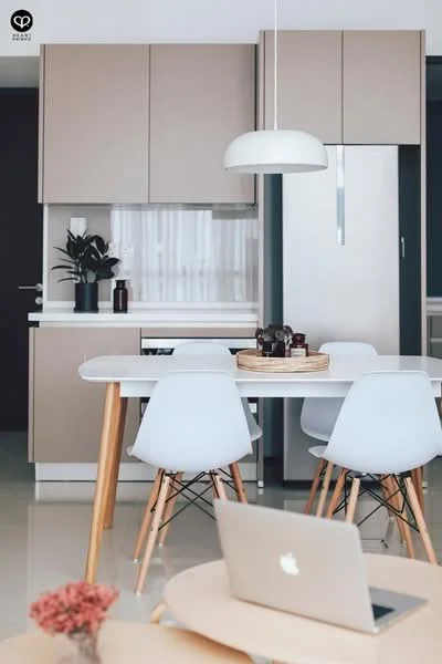 Kitchen features: light beige cabinetry, white countertop, stainless-steel fridge, white dining table, 4 white dining chairs with wooden legs, pendant light fixture, decorative plant on countertop, open shelving, kitchen sink, window with sheer curtains, ceramic tile flooring; style: modern.