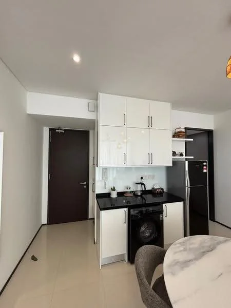 Kitchen features: black countertop, white cabinetry, built-in refrigerator, front-load washing machine, single-bowl stainless-steel sink, chrome pull-down faucet, ceramic tile flooring, recessed downlights, open shelving, decorative items on shelves, dining table with marble top, grey upholstered dining chairs; style: modern.