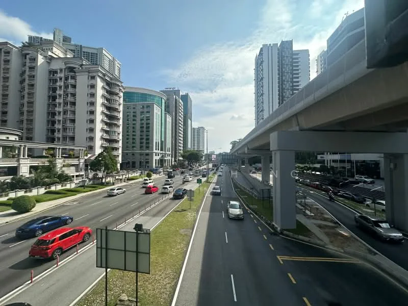 Exterior features: urban street view, multiple lanes of traffic, high-rise buildings, overhead train track, green landscaping along the road, clear blue sky, visible vehicles including red car, sidewalks along the street; style: modern.