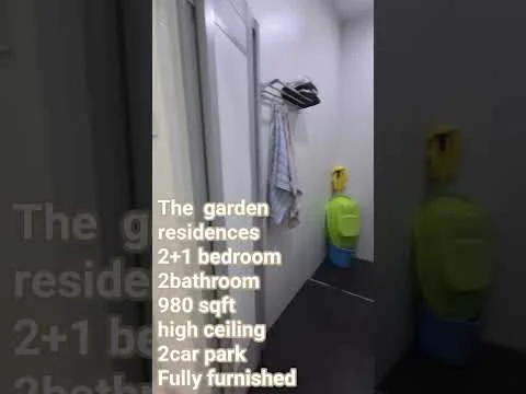 Room features: white painted walls, dark tile flooring, high ceiling, towel rack, hanging towel, yellow trash bin, green cleaning cart, door, light fixture.