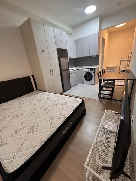 Room features: queen-size bed, mattress on bed frame, wooden flooring, grey cabinetry, stainless-steel fridge, built-in washing machine, white countertop, kitchen cabinets, dining table for 2, black dining chairs, wall-mounted TV, ceiling light, window with natural light; style: modern.