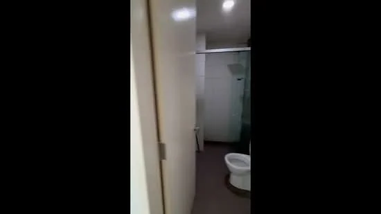 Bathroom features: white tiled walls, grey floor tiles, walk-in shower with glass enclosure, one-piece toilet, single-sink vanity with cabinet, mirror above vanity, recessed downlights, sliding glass door, shower head, toilet paper holder; style: modern.