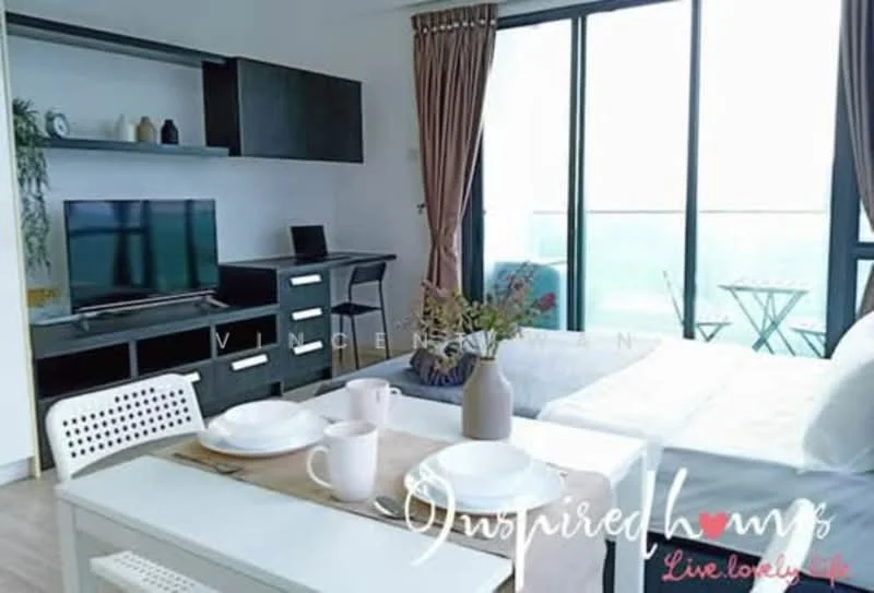 Living features: floor-to-ceiling windows, light wood flooring, white walls, black TV console, wall-mounted TV, black desk, white dining table, white chairs, decorative plants, beige curtains, small outdoor balcony with table and chairs, decorative vase, tableware on dining table; style: modern; view: city.