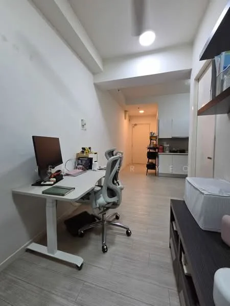 Study features: white painted walls, light wood flooring, desk with computer monitor, ergonomic office chair, shelves with books and decor, recessed ceiling lights, wall-mounted storage unit, doorway leading to kitchen area; style: modern.