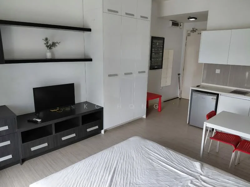 Room features: white walls, light wood flooring, built-in wardrobe with white doors, black TV console with drawers, wall-mounted TV, small dining table with white top and red chairs, mini fridge, kitchenette with white cabinetry, single-bowl stainless-steel sink, countertop with integrated stove, recessed ceiling lights; style: modern.