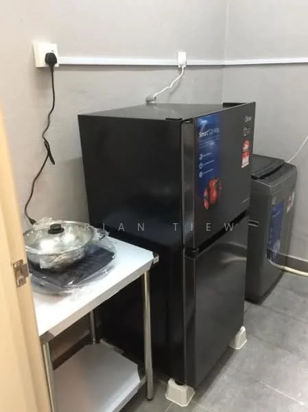Laundry features: black fridge, stainless-steel table, washing machine, grey tiled flooring, white walls, power outlet on wall, cable management on wall.