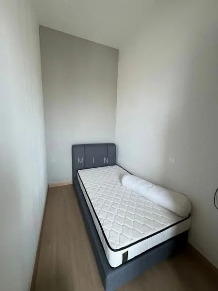 Bedroom features: single bed with grey upholstered headboard, mattress on bed frame, light wood flooring, white painted walls, no visible window treatments, minimalist decor, wall-mounted electrical outlet, blank wall with no decor; style: minimalist.