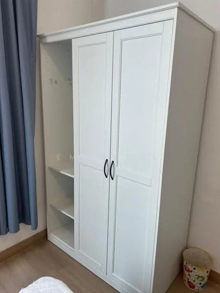 Room features: white wardrobe with double doors, open shelving on one side, wooden flooring, light-colored walls, curtains in blue, basket or bin on the floor; style: modern.