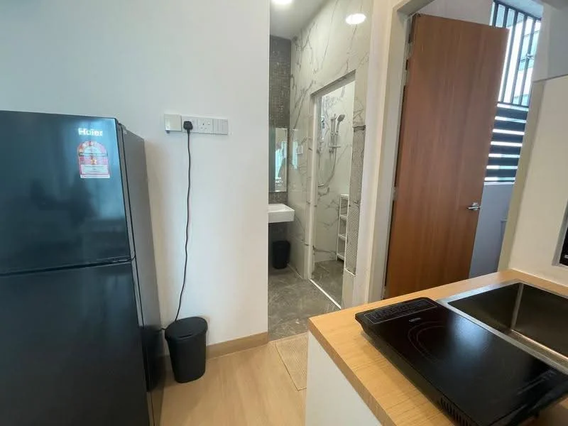 Kitchen features: black fridge, kitchen countertop, induction cooktop, wooden cabinetry, light wood flooring, wall-mounted electrical outlet, sink, open layout; style: modern. Bathroom features: shower with glass enclosure, toilet, sink, tile flooring, wall tiles, mirror, modern fixtures; style: modern.