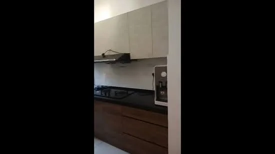 Kitchen features: black granite countertop, wood cabinetry with flat-panel design, light grey upper cabinets, built-in gas hob, stainless-steel range hood, built-in water dispenser, white tiled backsplash, recessed lighting; style: modern.