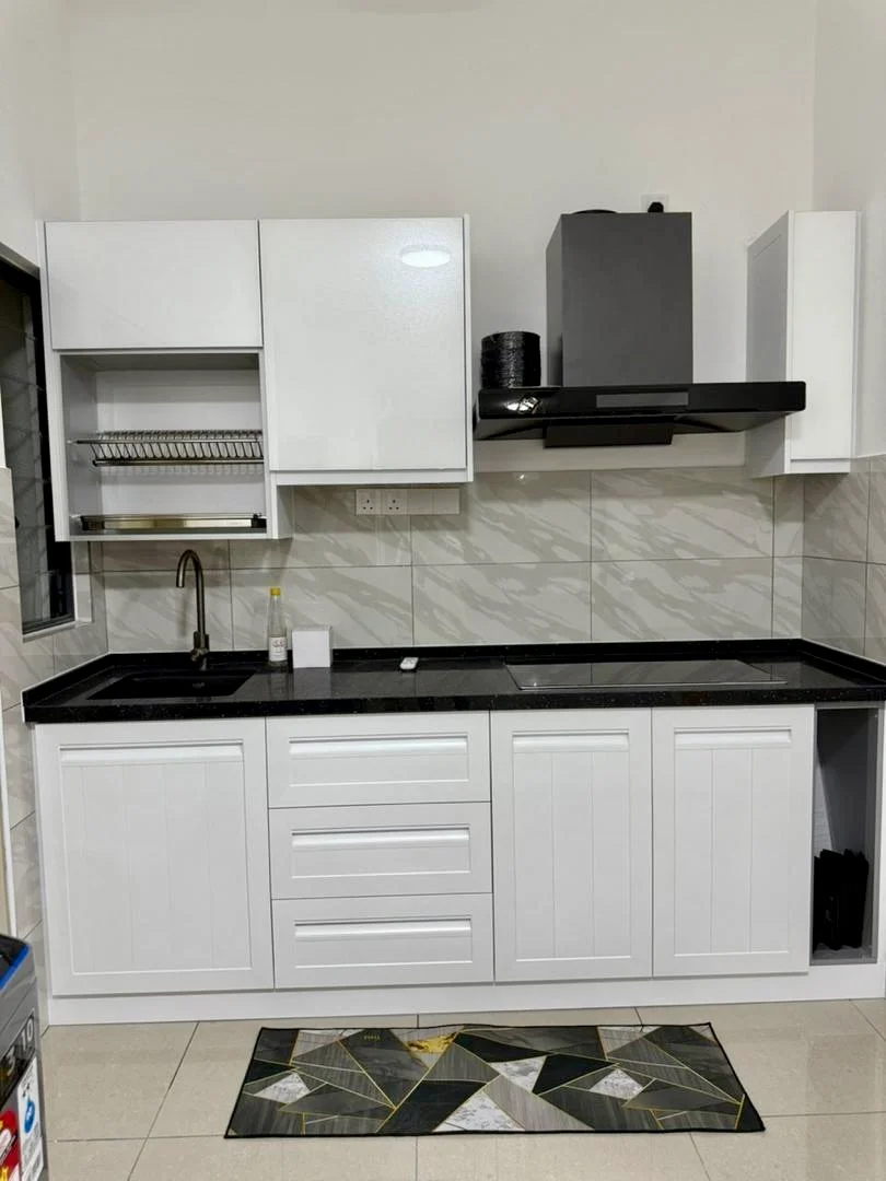 Kitchen features: white shaker cabinets, black granite countertop, single-bowl stainless-steel sink, chrome pull-down faucet, built-in range hood, wall-mounted cabinets, tile backsplash, ceramic tile flooring, recessed downlights, kitchen rug with geometric pattern; style: modern.