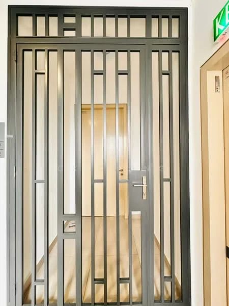 Room features: metal security gate, wooden door, light-colored walls, tile flooring, door handle, door lock, intercom panel, light fixture; style: modern.