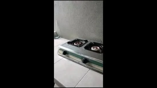 Kitchen features: 2-burner gas hob, stainless-steel cooktop, grey tiled backsplash, white tiled countertop, wall-mounted glass vase, textured wall surface; style: modern.