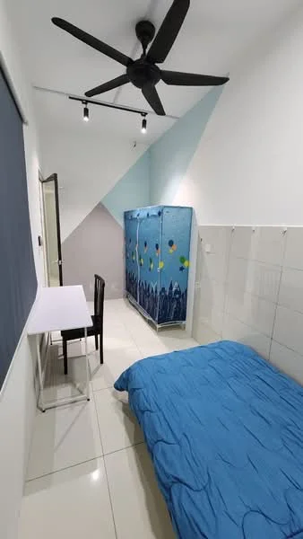 Bedroom features: blue bedspread, white walls with geometric accent, black ceiling fan, white tiled flooring, small study table, black chair, wardrobe with blue cover, wall-mounted hooks; style: modern.