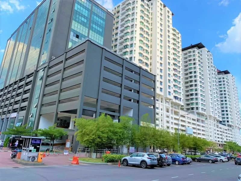 Exterior type: high-rise condominium; features: glass curtain wall, exposed concrete facade, multiple-storey structure, landscaped greenery at base, open-air parking lot, surrounded by mature trees, modern architectural design; style: modern.