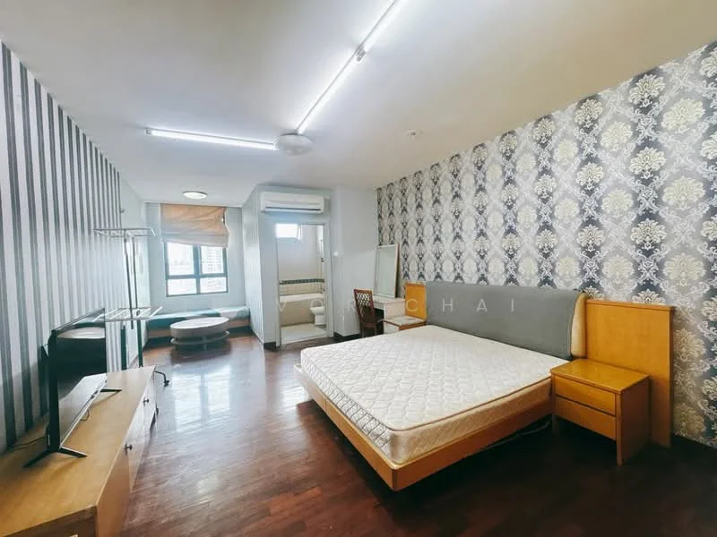 Bedroom features: queen-size bed, wooden bed frame, wooden bedside table, wall-mounted TV, laminate flooring, decorative wallpaper with floral pattern, striped accent wall, large window with city view, air conditioning unit, mirror, clothes rack, light fixture, ceiling light, curtains; style: modern; view: city.