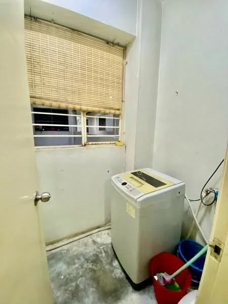 Laundry features: washing machine, window with blinds, grey concrete flooring, white painted walls, two plastic storage bins in red and blue.