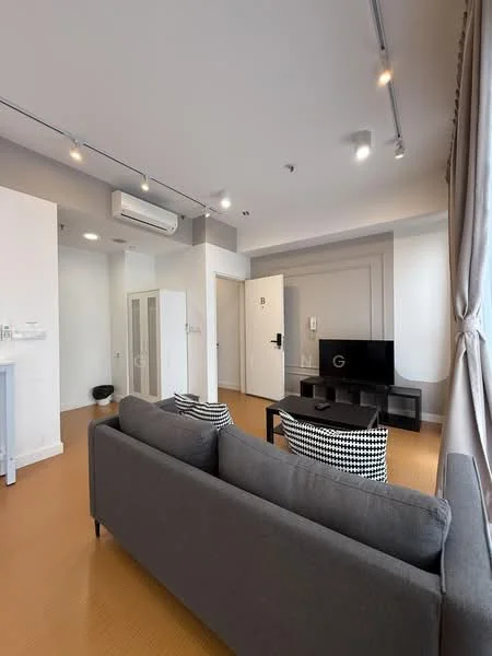 Living features: grey fabric sofa, black coffee table, wall-mounted TV, 1 wall-mounted split AC, light wood flooring, recessed downlights, curtains, decorative wall paneling, entrance door, white painted walls, built-in wardrobe, open layout; style: modern.