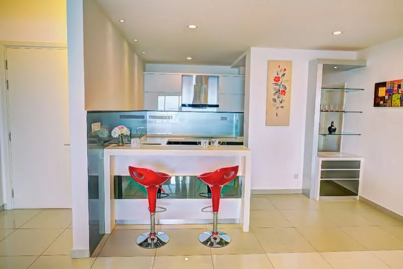Kitchen features: white cabinetry, stainless-steel appliances, built-in oven, 4-burner gas hob, single-bowl stainless-steel sink, chrome pull-down faucet, glass backsplash, bar counter with two red stools, recessed downlights, cream tiled flooring, open shelving, decorative wall art; style: modern.