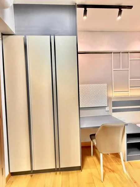 Room features: built-in wardrobe with sliding doors, light grey finish on wardrobe, study desk with wall-mounted pegboard, wooden flooring, recessed lighting, minimalist design, neutral color palette, chair with modern design; style: modern.