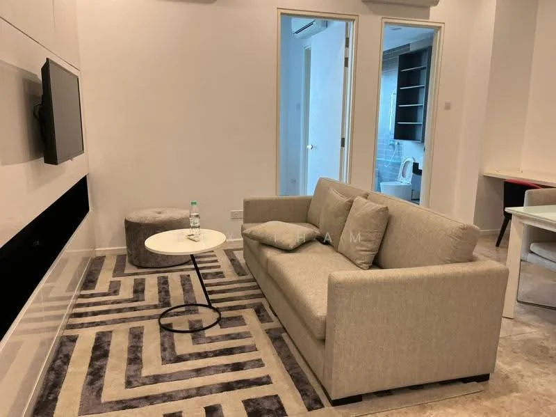 Living features: 3-seater fabric sofa in light grey, round coffee table with black base, area rug with geometric pattern in grey and white, wall-mounted TV, light-coloured walls, recessed downlights, floor-to-ceiling windows, decorative pouf in grey; style: modern. Room features: light-coloured walls, doorway leading to bathroom, doorway leading to another room.