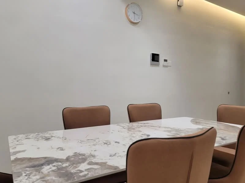 Dining features: marble dining table, 4 upholstered dining chairs in tan, wall clock, white painted walls, recessed lighting, smart thermostat, wall-mounted control panel; style: modern.