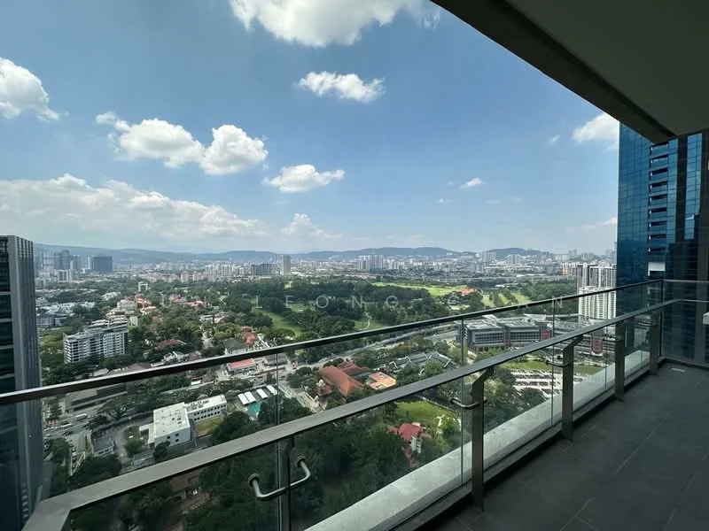 Exterior type: high-rise condominium; features: glass railing balcony, city skyline view, surrounded by greenery, modern architectural design, large glass windows, open-air balcony, panoramic views, urban landscape, high-rise structure, blue sky with clouds; style: modern.