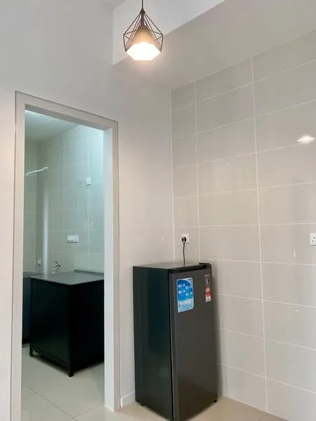 Room features: white tiled walls, light-colored floor tiles, black fridge, single pendant light, countertop with sink, wall-mounted electrical outlets, neutral color scheme; style: modern.