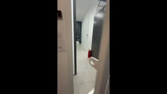 Room features: white painted walls, light-colored floor tiles, door frame, fire extinguisher, curtains, door, hallway lighting.