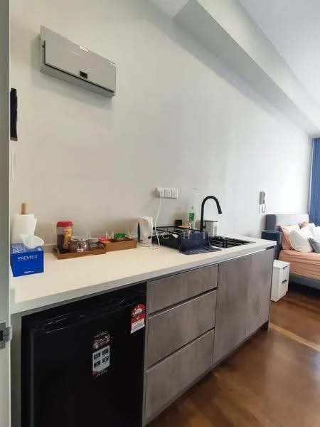 Kitchen features: white countertop, grey cabinetry, stainless-steel sink, chrome pull-down faucet, built-in gas hob, black fridge, wall-mounted split AC, wooden flooring, kitchen utensils on countertop, tissue box, small storage tray; style: modern.