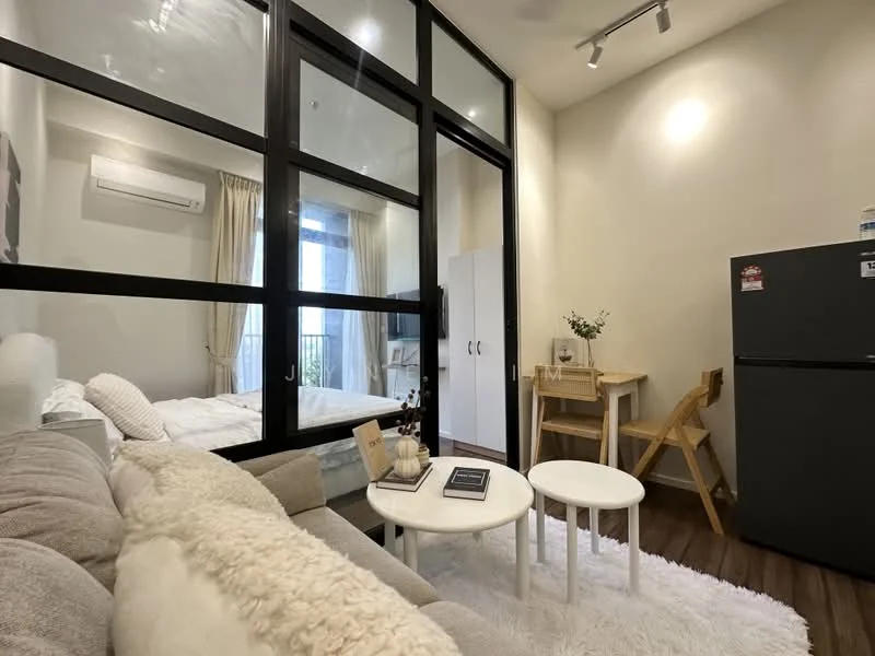 Living features: sofa with plush fabric in light grey, 2 small round coffee tables in white, area rug in white, wall-mounted split AC, wooden flooring, floor-to-ceiling glass partition, decorative plant on table, fridge in dark grey, light-colored walls, curtains in light beige; style: modern; view: city. Bedroom features: queen-size bed with white bedding, built-in wardrobe in white, window with sheer curtains; style: modern; view: city.