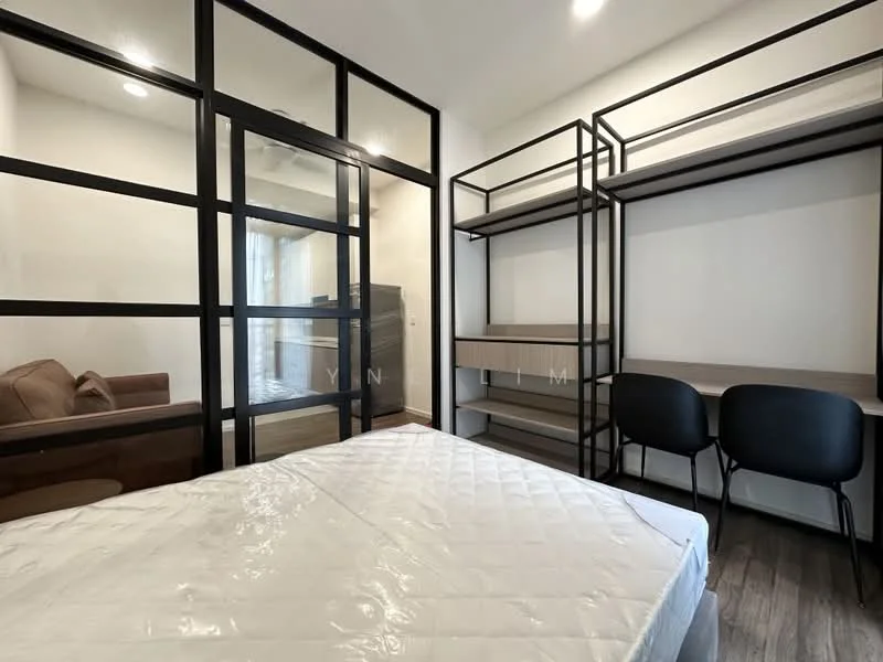 Bedroom features: queen-size bed, black metal bed frame, white mattress, black shelving unit, wooden bedside table, two black chairs, glass partition wall, sofa in background, wooden flooring, recessed lighting; style: modern.