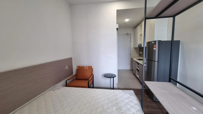 Room features: queen-size bed, wooden headboard, orange upholstered armchair, round side table, stainless-steel fridge, kitchenette with countertop, wall-mounted cabinets, grey tile flooring, white painted walls, recessed ceiling lights; style: modern.