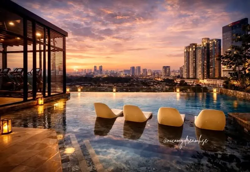 Exterior type: swimming pool deck; features: infinity pool, poolside loungers, landscape lighting, city skyline view, stone-paved deck, wooden pergola, outdoor seating area, surrounding greenery; style: modern.