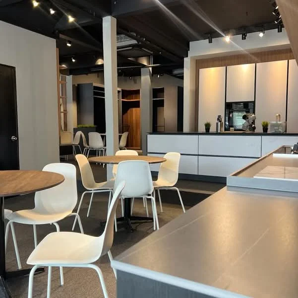 Kitchen features: white cabinetry, grey countertop, stainless-steel sink, built-in appliances, recessed lighting, open shelving, bar stools, modern design, wooden dining table, white dining chairs, carpeted flooring, black accent wall; style: modern.