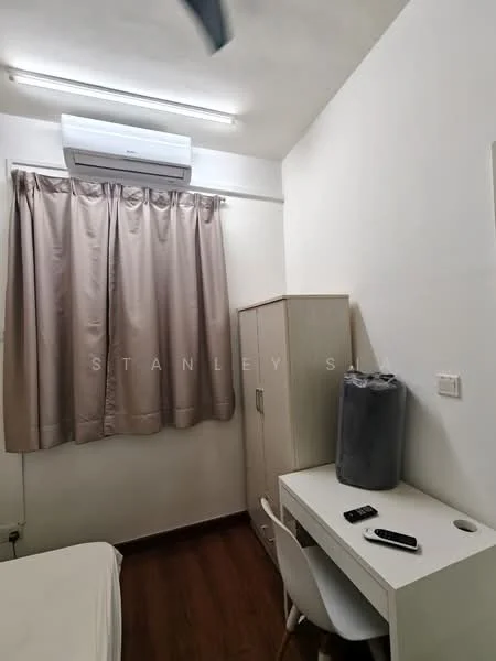 Room features: light wood flooring, white painted walls, curtains in beige, wall-mounted split AC unit, built-in wardrobe with light wood finish, desk with white surface, white chair, remote control on desk, grey storage container on desk; style: modern.