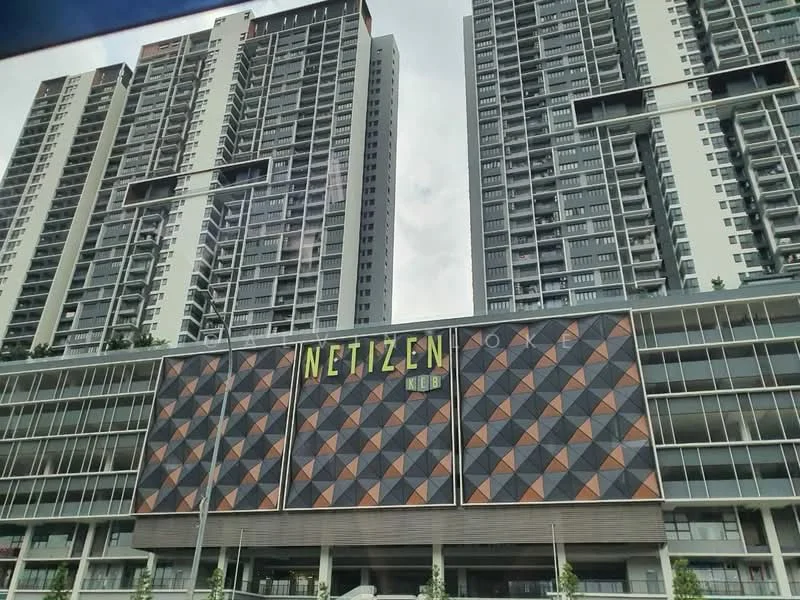 Exterior type: high-rise condominium; features: glass curtain wall, geometric patterned facade, multi-storey building, balconies on upper floors, commercial space at ground level, signage with 'NETIZEN' branding, landscaped area at the base, surrounded by urban environment; style: modern.