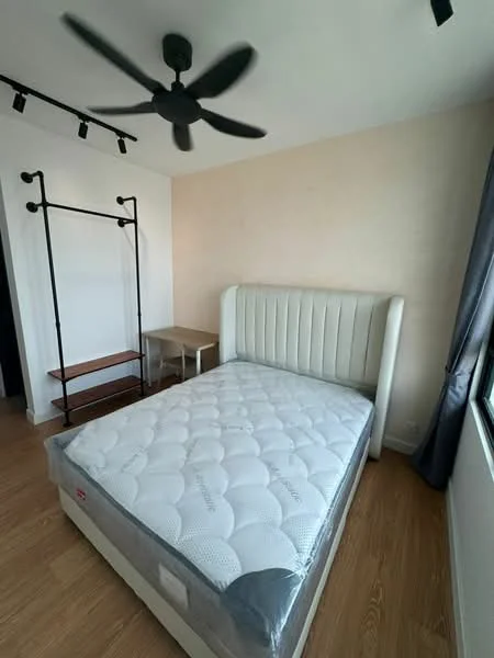 Bedroom features: king-size bed with upholstered headboard, mattress on bed frame, wooden flooring, 5-blade ceiling fan, window with grey curtains, study desk, wooden shelving unit, light-colored painted walls; style: modern.