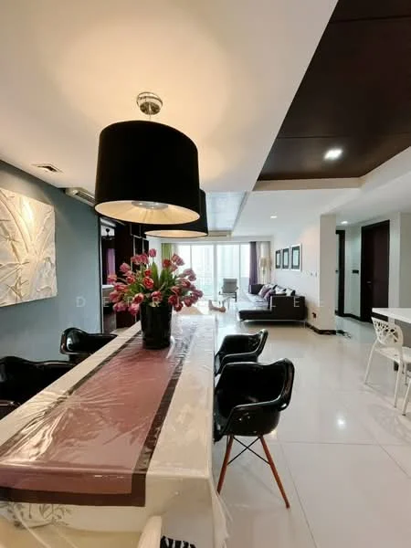 Dining features: long dining table with protective cover, black dining chairs with wooden legs, pendant lamp with black shade, decorative vase with flowers, white walls, marble tile flooring; style: modern. Living features: sofa in dark color, coffee table, wall-mounted artwork, floor-to-ceiling windows, curtains, recessed ceiling lights, white walls, marble tile flooring; style: modern.