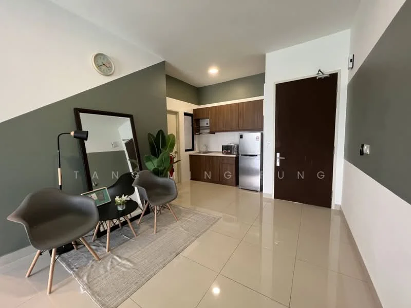 Living features: grey accent wall, white painted walls, glossy tile flooring, 2 modern armchairs in grey, decorative mirror, small coffee table, houseplant in ceramic pot, area rug, wall clock, recessed downlights; style: modern. Kitchen features: wood cabinetry, stainless-steel fridge, built-in oven, 4-burner gas hob, kitchen countertop, open shelving; style: modern.