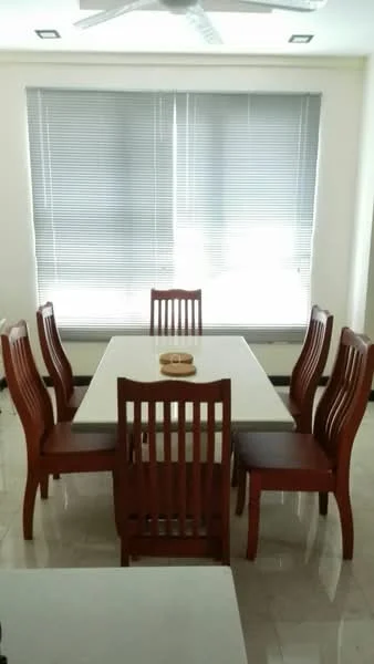 Dining features: 6-seater dining table, white tabletop, wooden dining chairs, slatted back chairs, window with vertical blinds, marble tile flooring, ceiling fan with light, decorative bowl on table; style: modern.