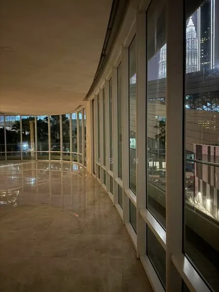 Room features: curved glass walls, marble flooring, city skyline view, night lighting, high ceilings, open space, modern design; style: modern; view: city.