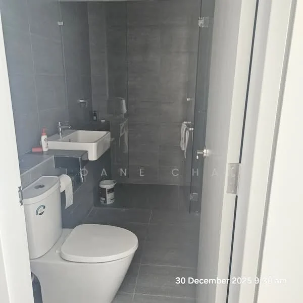 Bathroom features: grey tiled walls, grey tiled flooring, white wall-mounted sink, chrome basin mixer faucet, one-piece toilet, towel rail, toilet paper holder, mirror above sink; style: modern.