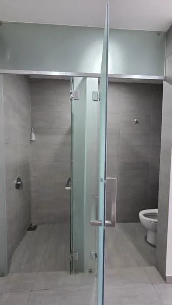 Bathroom features: glass shower enclosure, walk-in shower, chrome shower faucet, grey tiled walls, light grey floor tiles, toilet, wall-mounted toilet paper holder, recessed lighting; style: modern.