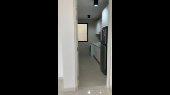 Kitchen features: white cabinets, stainless-steel fridge, built-in oven, ceramic tile flooring, white walls, recessed downlights, countertop, sink, washing machine, window, open layout; style: modern.
